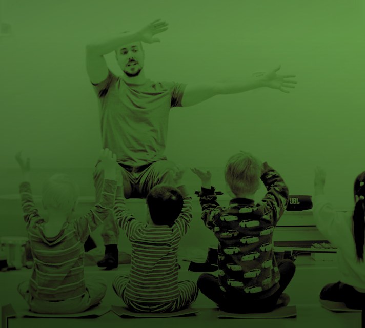Children and a teacher moving to music in music playschool